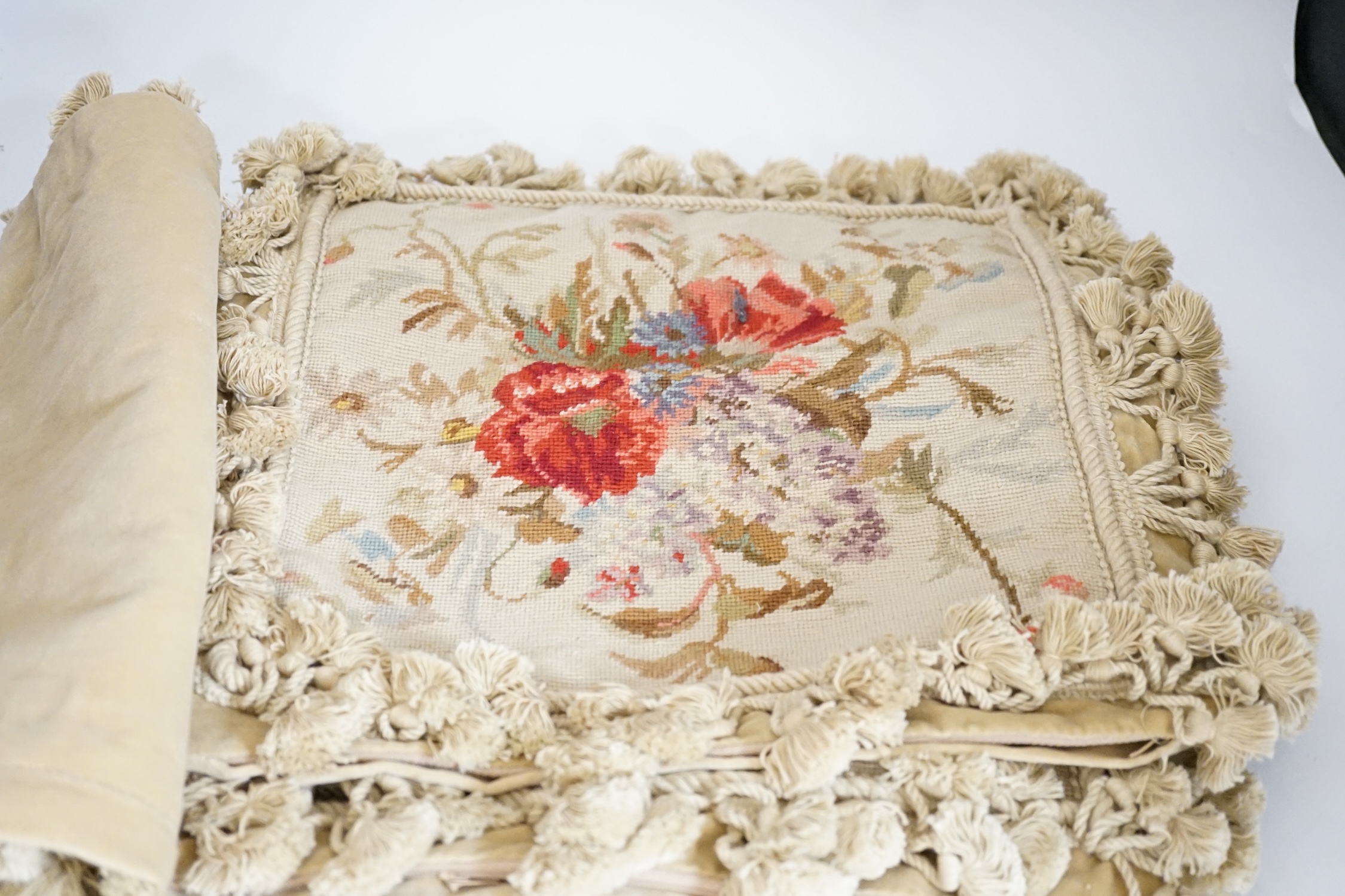 Five square wool worked cushion covers designed with wild flowers, bordered with tasselled braiding